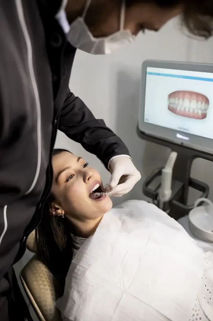 Female patient receiving dental treatment while lying in dental chair, with dentist wearing black gloves using dental instruments